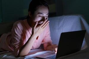 foto di giovane asiatico donna utilizzando il computer portatile nel il buio a mezzanotte