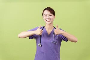 foto di giovane asiatico femminile medico su verde sfondo