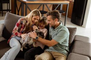 famiglia bonding tempo con giocoso francese bulldog cucciolo nel accogliente vivente camera foto