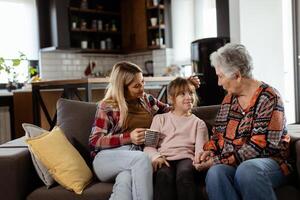 generazionale legame, nonna, figlia, e nipote condivisione storie su un' accogliente pomeriggio foto