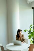 pensieroso professionale donna impegna nel in profondità pensato a un' luminosa ufficio spazio. foto