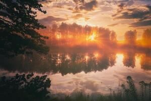 alba su un' lago o fiume con un' cielo riflessa nel il acqua, betulla alberi su il riva e il raggi di sole rottura attraverso loro e nebbia nel autunno. estetica di Vintage ▾ film. foto
