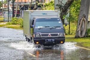 parecchi veicoli come come camion, biciclette e macchine erano intrappolati di acqua di inondazione nel greco reggenza, Indonesia, 21 febbraio 2024. foto