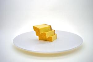tre fette di formaggio torta su un' bianca piatto con un' pianura sfondo foto