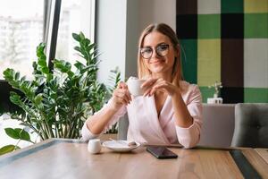 sorridente donna d'affari utilizzando tavoletta computer caffè negozio foto