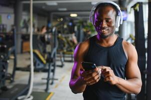 fiducioso ateo con cuffie nel Palestra foto