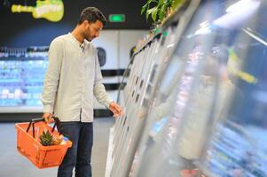 ritratto di bello giovane indiano uomo in piedi a drogheria negozio o supermercato, avvicinamento. selettivo messa a fuoco. foto