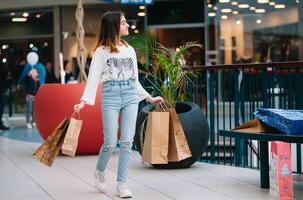 Al dettaglio, gesto e vendita concetto - sorridente adolescenziale ragazza con molti shopping borse a centro commerciale. foto