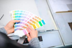 tipografo in piedi con colore campioni a il stampa produzione foto