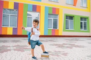 carino scolaro nel bianca camicie e un' bicchieri con libri e un' zaino. indietro per scuola foto