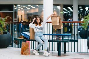 shopping volta, adolescenziale ragazza con shopping borse a shopping centro commerciale. shopping concetto foto