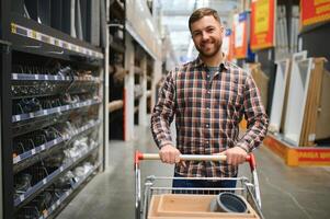 ritratto di contento maturo uomo in piedi nel hardware memorizzare foto