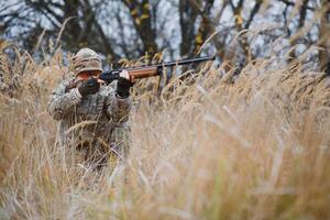 cacciatore nel uniforme con un' a caccia fucile. a caccia concetto. foto