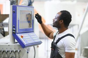 ritratto di africano americano maschio ingegnere nel uniforme e in piedi nel industriale fabbrica foto