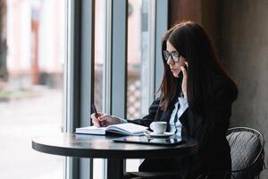 giovane donna d'affari parlando su il Telefono nel caffè negozio. foto