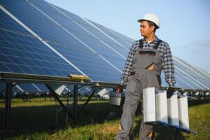 un indiano maschio lavoratore è Lavorando su installazione solare pannelli nel un' campo foto