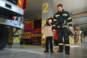 pompiere Tenere bambino ragazzo per Salva lui nel fuoco e fumo, vigili del fuoco salvare il ragazzi a partire dal fuoco foto