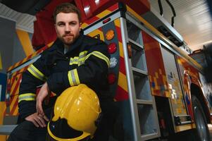 pompiere nel uniforme e casco vicino fuoco motore foto