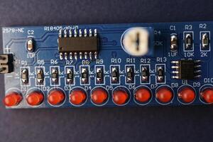 un' stampato circuito tavola con Radio elementi. led e patatine fritte. un' impostato per saldatura un dilettante Radio. foto