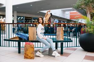 Al dettaglio, gesto e vendita concetto - sorridente adolescenziale ragazza con molti shopping borse a centro commerciale. shopping concetto foto