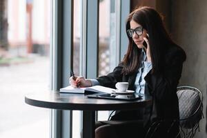 giovane donna d'affari parlando su il Telefono nel caffè negozio. foto