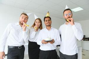 sorpresa. misto gara contento persone festeggiare un' compleanno di collega nel il moderno ufficio foto