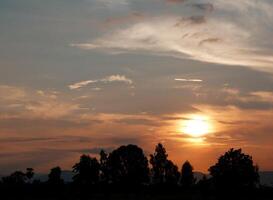 spettacolare tramonto Sopra, arancia sole crescente su al di sopra di il orizzonte foto