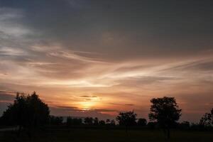 spettacolare tramonto Sopra, arancia sole crescente su al di sopra di il orizzonte foto