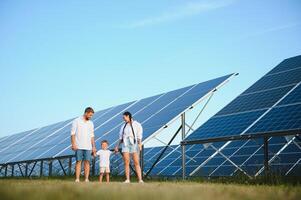 contento giovane famiglia vicino solare pannelli. solare energia. foto