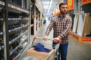 ritratto di contento maturo uomo in piedi nel hardware memorizzare foto