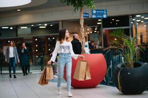 shopping volta, adolescenziale ragazza con shopping borse a shopping centro commerciale foto