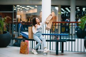 shopping volta, adolescenziale ragazza con shopping borse a shopping centro commerciale. shopping concetto foto