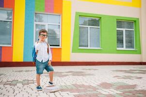 carino scolaro nel bianca camicie e un' bicchieri con libri e un' zaino. indietro per scuola. foto