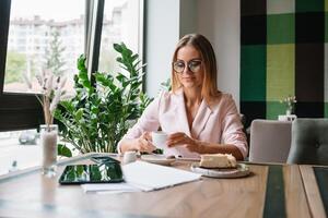 sorridente donna d'affari utilizzando tavoletta computer caffè negozio foto