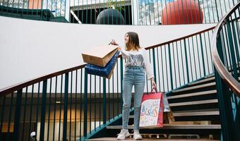 Al dettaglio, gesto e vendita concetto - sorridente adolescenziale ragazza con molti shopping borse a centro commerciale. shopping concetto foto