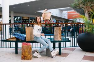 Al dettaglio, gesto e vendita concetto - sorridente adolescenziale ragazza con molti shopping borse a centro commerciale. shopping concetto foto