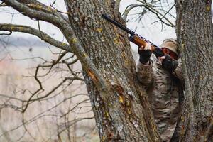 a caccia permesso. uomo brutale guardiacaccia natura sfondo. cacciatore trascorrere tempo libero a caccia. cacciatore hold riffle. messa a fuoco e concentrazione di esperto cacciatore. a caccia e intrappolamento le stagioni foto