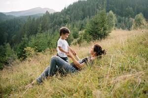 giovane mamma con bambino ragazzo in viaggio. madre su escursioni a piedi avventura con bambino, famiglia viaggio nel montagne. nazionale parco. escursione con bambini. attivo estate vacanze. fisheye lente. foto