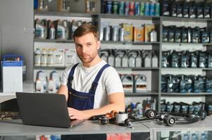 un' venditore nel un auto parti negozio. Al dettaglio commercio di auto parti foto