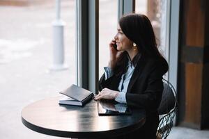 giovane donna d'affari parlando su il Telefono nel caffè negozio foto