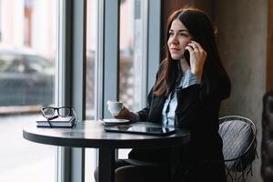 giovane donna d'affari parlando su il Telefono nel caffè negozio. foto