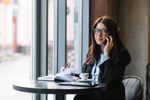 giovane donna d'affari parlando su il Telefono nel caffè negozio. foto