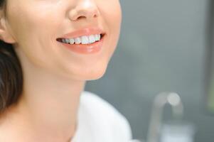 stomatologia concetto, parziale ritratto di ragazza con forte bianca denti. avvicinamento di giovane donna a dal dentista, studio, in casa foto