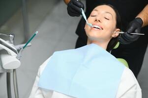 dentista che esamina i denti di un paziente nel dentista foto