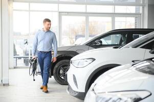 giovane uomo acquisto primo elettrico auto nel il showroom. eco auto vendita concetto foto