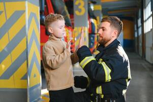 pompiere Tenere bambino ragazzo per Salva lui nel fuoco e fumo, vigili del fuoco salvare il ragazzi a partire dal fuoco foto