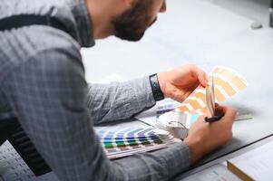 tipografo in piedi con colore campioni a il stampa produzione foto