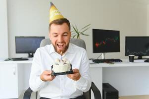 giovane uomo d'affari festeggiare compleanno solo nel ufficio foto