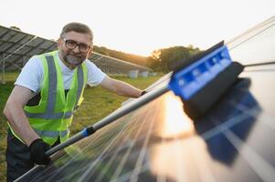 professionale lavoratore pulizia solare pv pannello. uomo fabbricazione sicuro solare batterie nel bene condizione foto