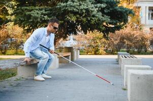 cieco uomo. visivamente alterata uomo con a piedi bastone, foto